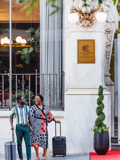 Man and woman laughing outside hotel